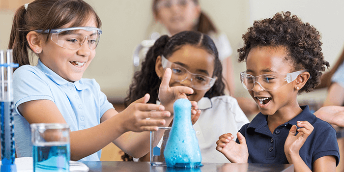 Kids in a classroom learning with a chemistry set